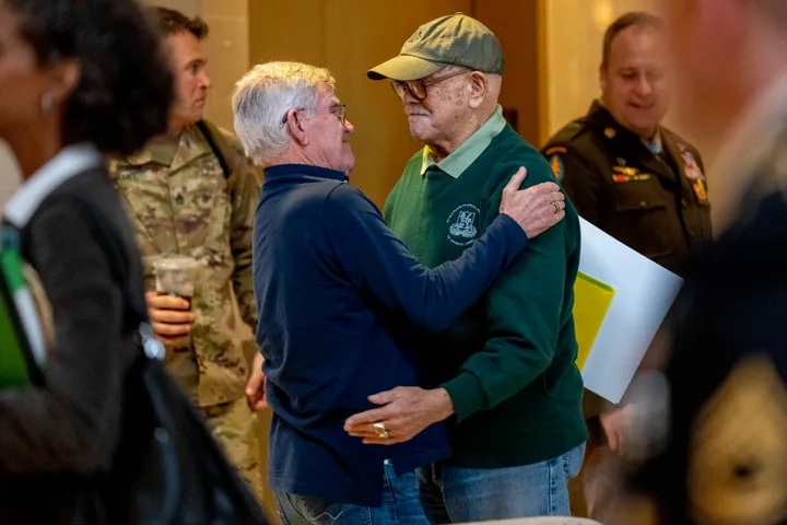 Retired Army Col. Paris Davis, an Ohio native, who is set to receive the Medal of Honor for his service in the Vietnam War, hugs his friend Jim Moriarty before sitting down for an interview with the Associated Press at a hotel in Arlington, Va., on March 2, 2023. AP PHOTO/ANDREW HARNIK